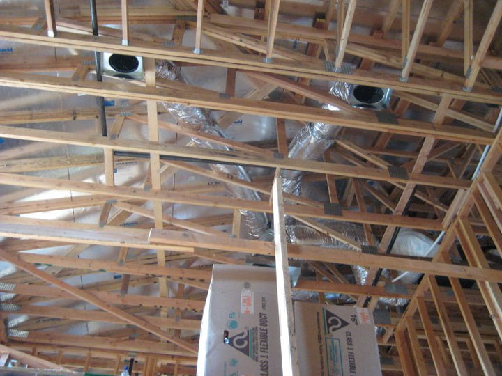 Exposed roof trusses with HVAC ductwork and insulation