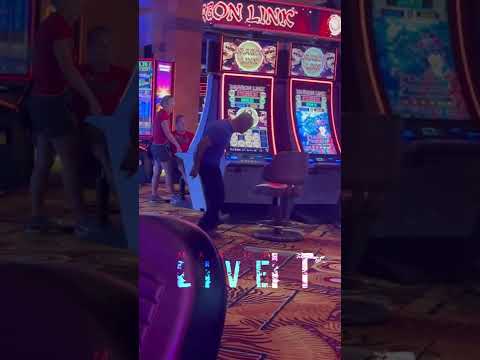 People at neon-lit slot machines in casino